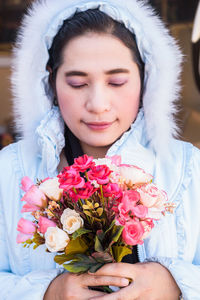 Portrait of beautiful woman holding flower bouquet