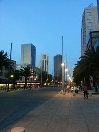 Illuminated buildings against clear blue sky