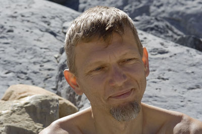 Shirtless mature man against rocks