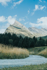 Scenic view of snowcapped mountains against sky with a road leading towards them.