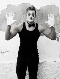 Portrait of beautiful young woman standing against wall