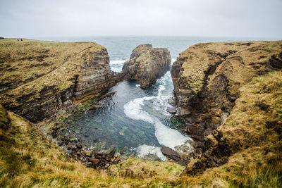 Panoramic view of rocks on beach against sky