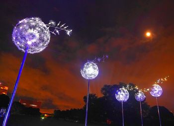 Low angle view of illuminated fireworks against sky at night