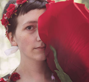 Close-up portrait of woman with red flower