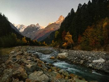 River flowing by mountains against sky
