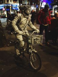 Man cycling on street in city at night