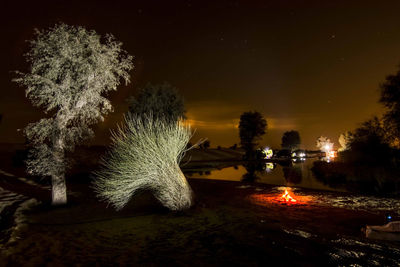 Bonfire at lakeshore during night