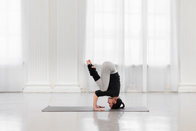 Side view of woman exercising at home