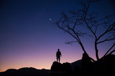 Low angle view of silhouette man standing against sky at sunset