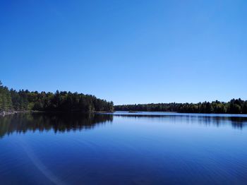 Scenic view of lake against clear blue sky