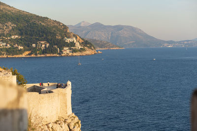 Scenic view of sea and mountains against sky