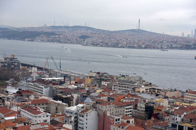 High angle view of townscape by sea against sky