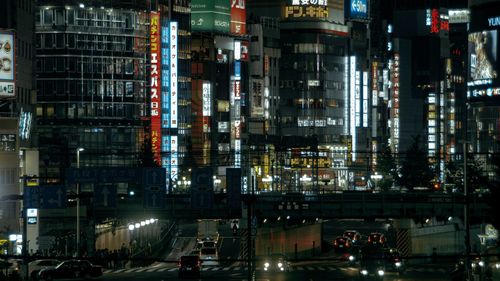 Illuminated city street and buildings at night