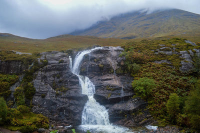 Scenic view of waterfall against sky