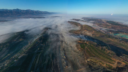 High angle view of land and sea against sky