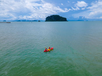 High angle view of man kayaking in sea against sky