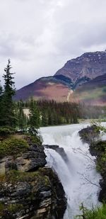 Scenic view of waterfall against sky