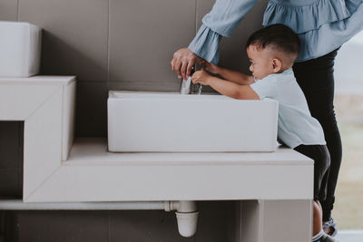 Rear view of father and son standing on table