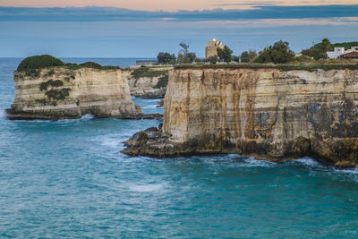 Rock formations by sea against sky 