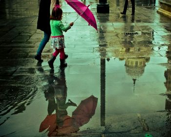 Low section of man standing on puddle