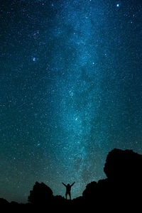 Low angle view of silhouette man against sky at night