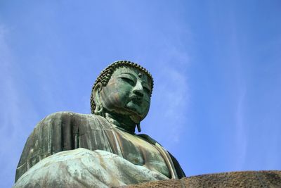 Low angle view of statue against blue sky