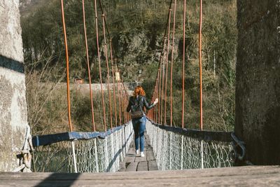Woman walking on a rope bridge