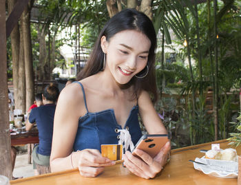 Happy young woman sitting on table