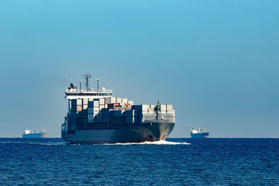 Ship sailing on sea against clear sky
