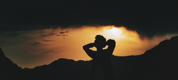 Silhouette friends standing against sky during sunset