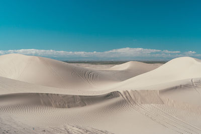 Sand dunes in desert against sky