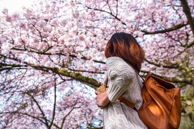 Woman with pink cherry blossoms in spring