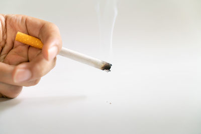 Close-up of hand holding cigarette