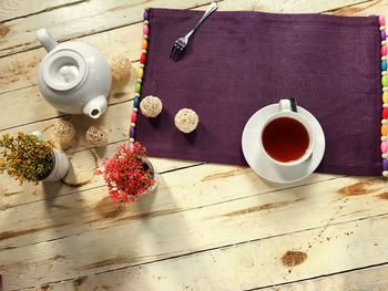 Directly above shot of teapot and tea with decoration on wooden table