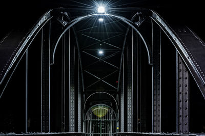 Low angle view of illuminated bridge against sky at night