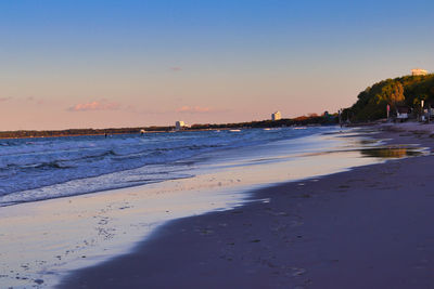 Scenic view of beach against sky at sunset