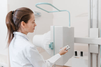 Side view of doctor inspecting machine in hospital