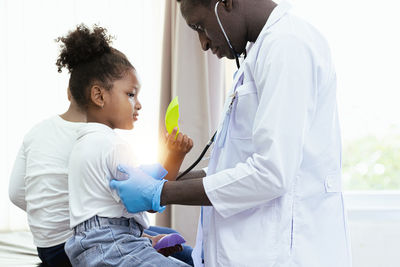Doctor examining girl at clinic