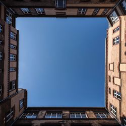 Low angle view of buildings against clear blue sky
