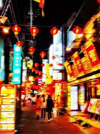 Woman standing in illuminated city at night