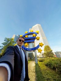 Portrait of businessman standing against building