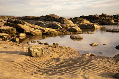 Rocks on beach against sky