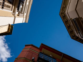 Low angle view of buildings against clear blue sky