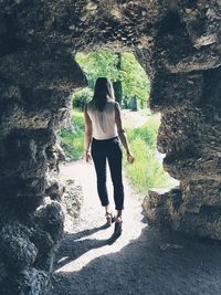 Rear view of woman walking on rock