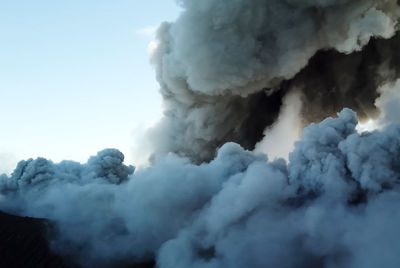 Smoke emitting from volcanic mountain against sky
