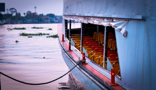 Boat in river by building against sky