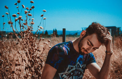 Young man looking away on field