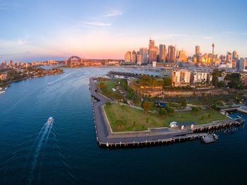 Aerial view of buildings and sea against sky during sunset