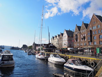 Boats moored in river with buildings in background