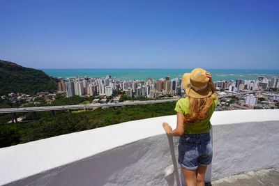Panoramic view of traveler woman with hat in vila velha, vitoria metropolitan region, brazil.